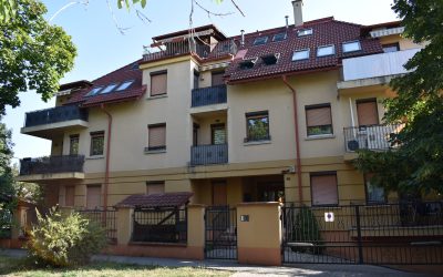 Társasház több erkélyes homlokzattal és piros tetőcserepekkel